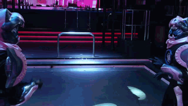 two robots are standing next to each other in front of a stage