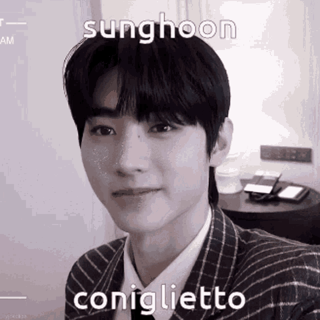 a young man in a suit is taking a selfie with a caption that reads sunghoon coniglietto .