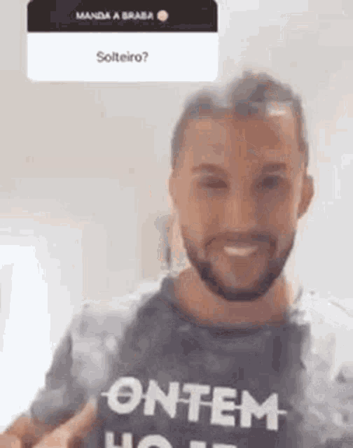 a man with a beard is wearing a t-shirt that says ' ontem hoje ' on it .