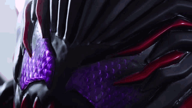 a close up of a black object with purple and red spots