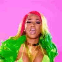 a woman with red hair and green hair is wearing a green jacket and a green top .