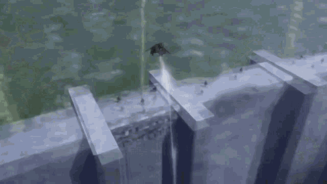 a helicopter is flying over a concrete wall with a bullet coming out of it .