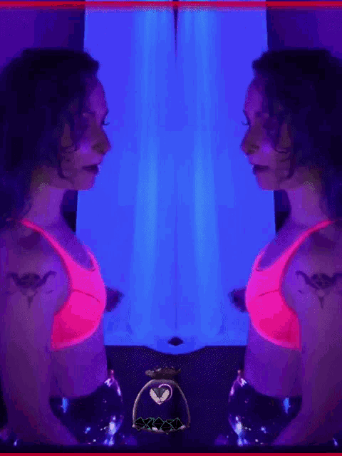 a woman in a pink top is standing in front of a purple wall