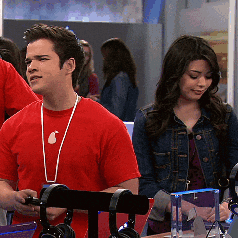 a man wearing a red shirt with an apple on it stands next to a woman