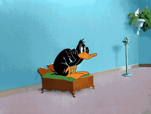 a cartoon of daffy duck sitting on a bed