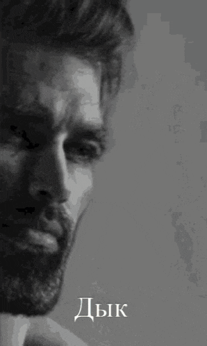 a black and white photo of a man with a beard and the word dzk on the bottom right