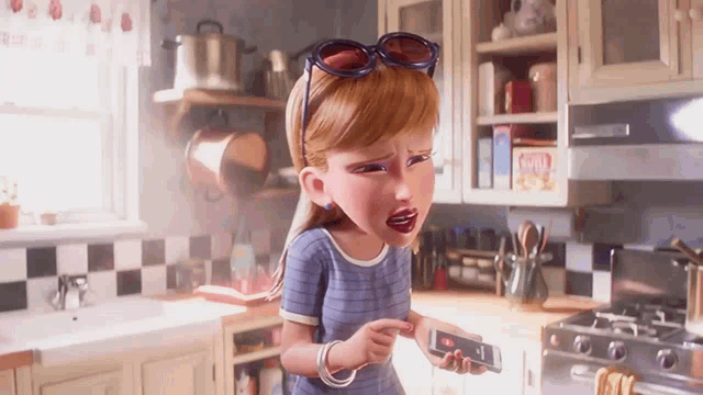 a cartoon girl is standing in a kitchen holding a cell phone .