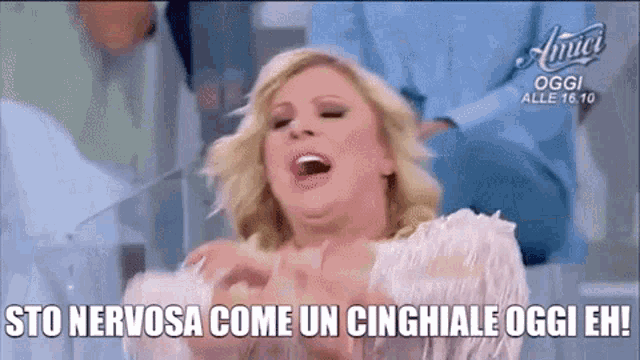 a woman sitting at a table with her mouth open and the words sto nervosa come un cinghiale oggi eh .