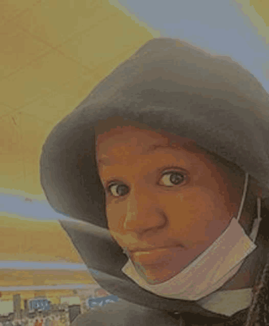 a close up of a person wearing a hooded jacket and a mask .
