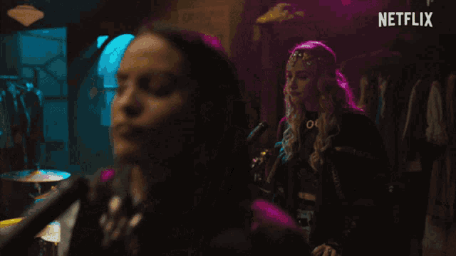 a woman is singing into a microphone with a netflix logo behind her