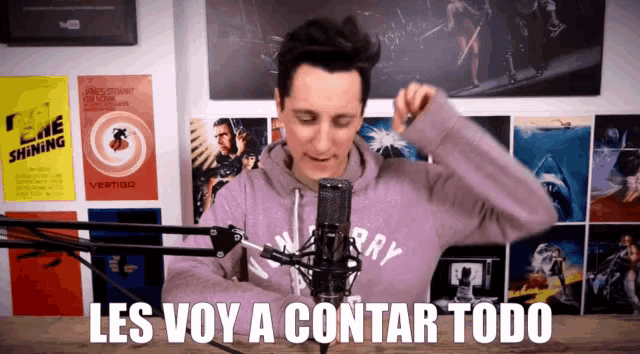 a man stands in front of a microphone with the words les voy a contar todo written below him