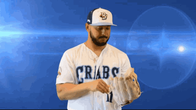 a man in a crabs jersey holds a glove