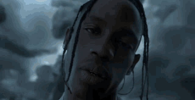 a man with dreadlocks is looking at the camera