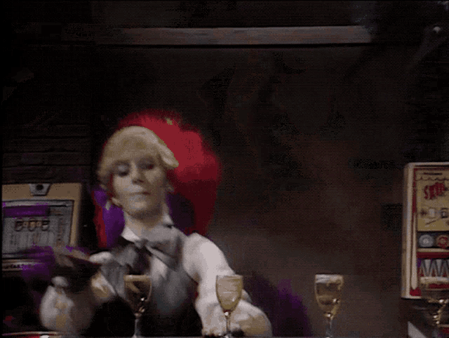 a woman in a striped vest is drinking a glass of wine