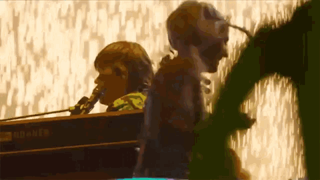 a man singing into a microphone while another man plays a keyboard that says yamaha