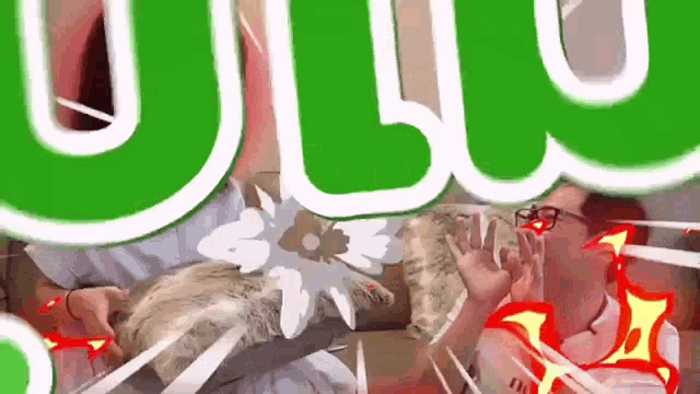 a man is sitting on a couch with a cat and a green sign that says ' ulu ' on it .