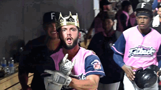 a baseball player wearing a crown and a pink jersey with the letter f on the front