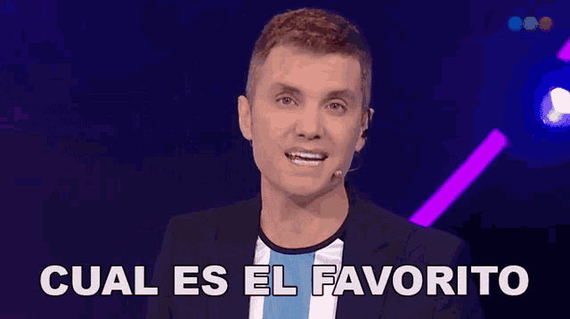 a man in a suit is speaking into a microphone and the words cual es el favorito are above him