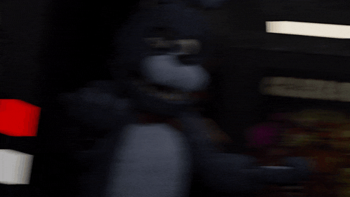 a blurred image of a bear in a dark room with a red and white light behind it