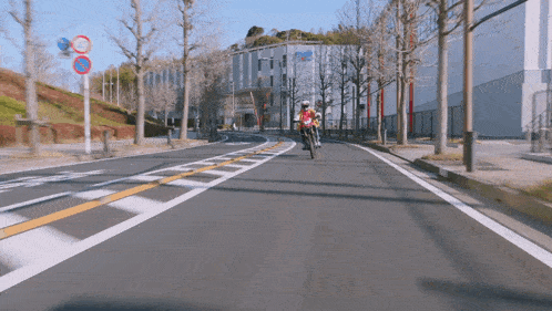 a person riding a motorcycle down a road with a no parking sign