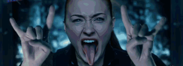 a woman is sticking out her tongue and making a devil horns sign .