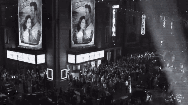 a crowd of people are gathered in front of a building with a sign that says ' cinema ' on it