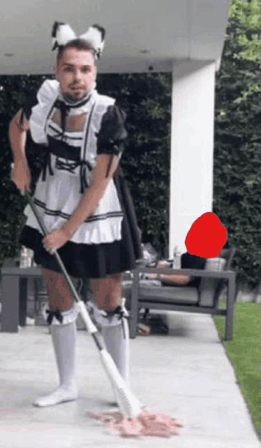 a man dressed as a maid is mopping the ground