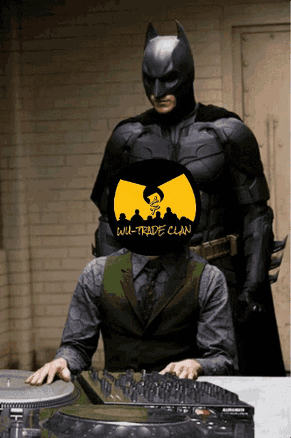 a man in a green vest is sitting at a table with a wu-trade clan logo on his head