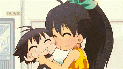a girl is kissing a boy on the cheek in front of a sign that says ' a ' on it