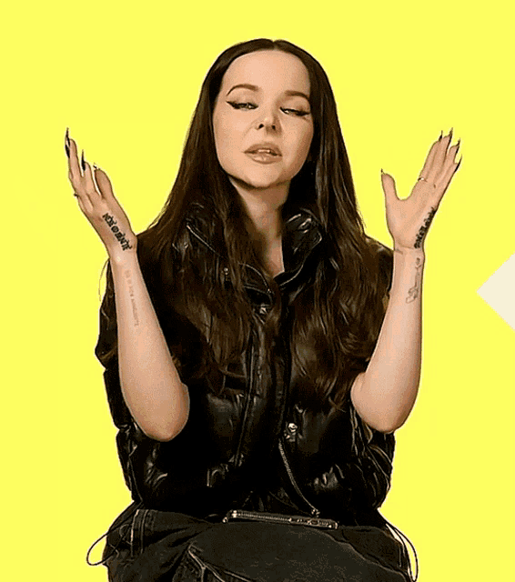 a woman in a leather jacket has a tattoo on her arm that says ' i love you '