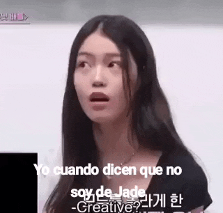 a woman with long black hair is making a funny face while talking in a foreign language .