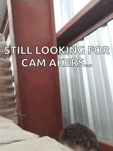 a man looking out a window with the words still looking for cam makers written below him