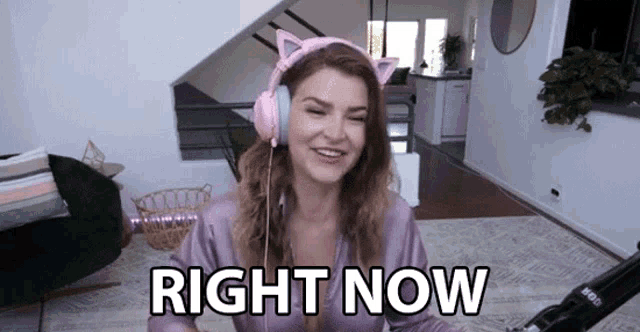 a woman wearing cat ears says right now