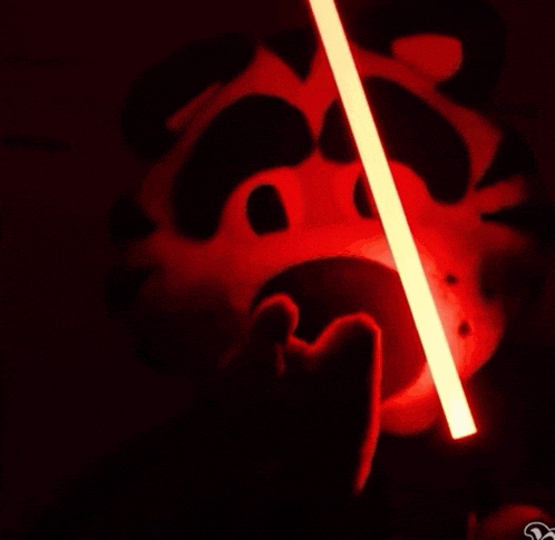 a red light beam is coming out of a hole in a black background