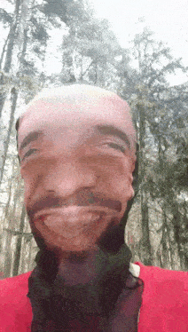 a man with a beard and a red shirt is making a funny face