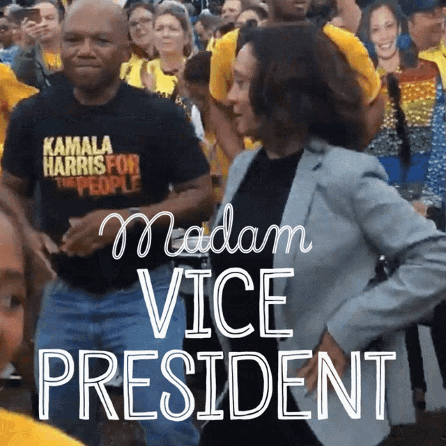 a man in a kamala harris for the people shirt is dancing with a woman