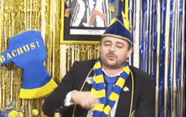 a man wearing a blue and yellow scarf with the word bachus written on it