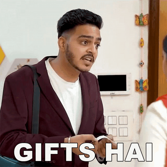a man in a suit says gifts hai in front of a wall with butterflies