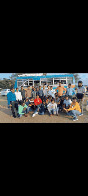 a group of people are posing for a photo in front of a bus .