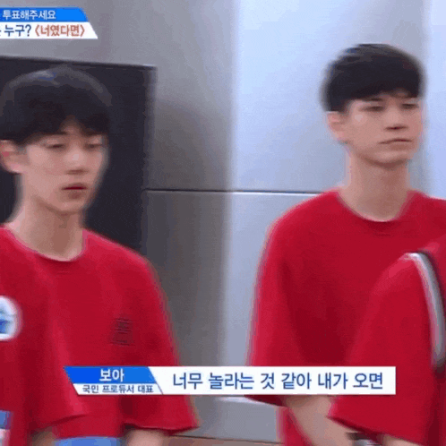 a blurry picture of two young men in red shirts