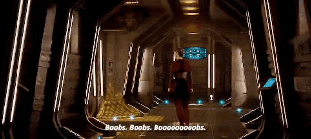 a woman in a red costume is walking down a hallway in a futuristic spaceship .