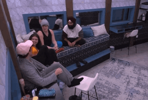 a group of people are sitting on a couch talking