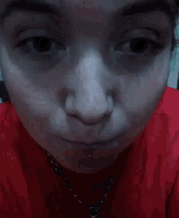 a close up of a woman 's face with a red shirt