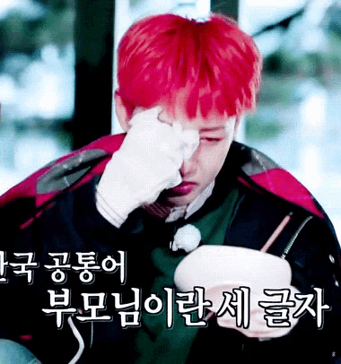 a man with red hair wipes his eyes with a tissue