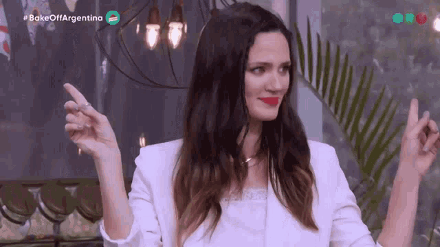 a woman is dancing in front of a sign that says #bake off argentina