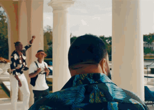 a man in a hawaiian shirt is standing in front of a group of men