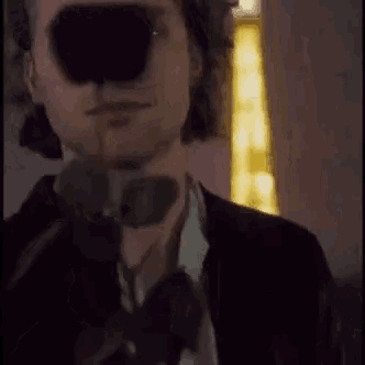 a man in a suit and tie is holding a rose in his hand .