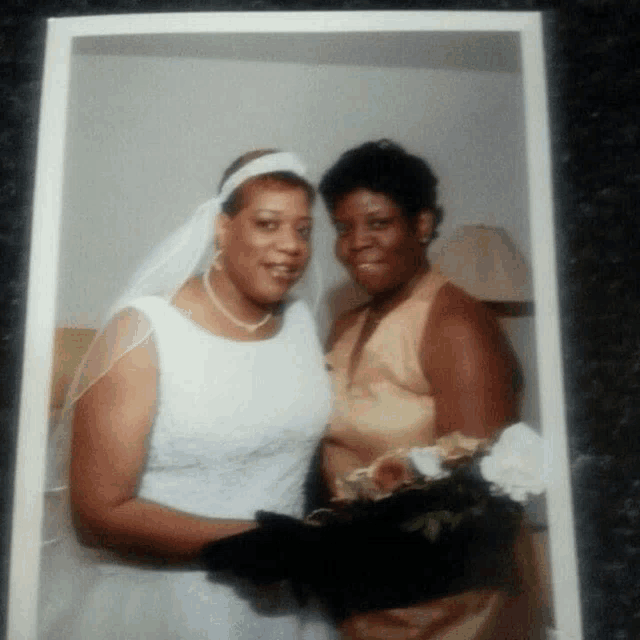 a bride and her mother pose for a picture together