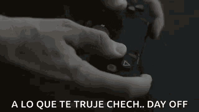 a close up of a person holding a video game controller with the words " a lo que te true chech day off " below it