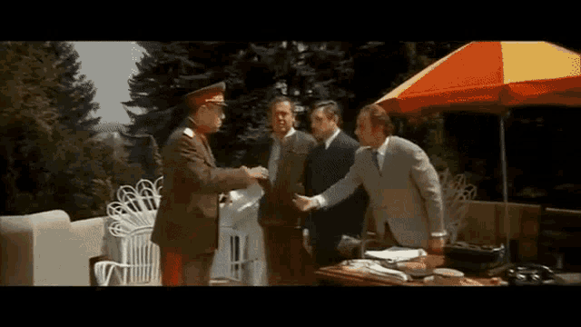 a man in a military uniform shakes hands with another man